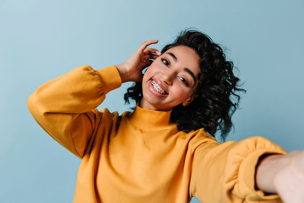 A girl with the advantage of metal braces to straighten teeth