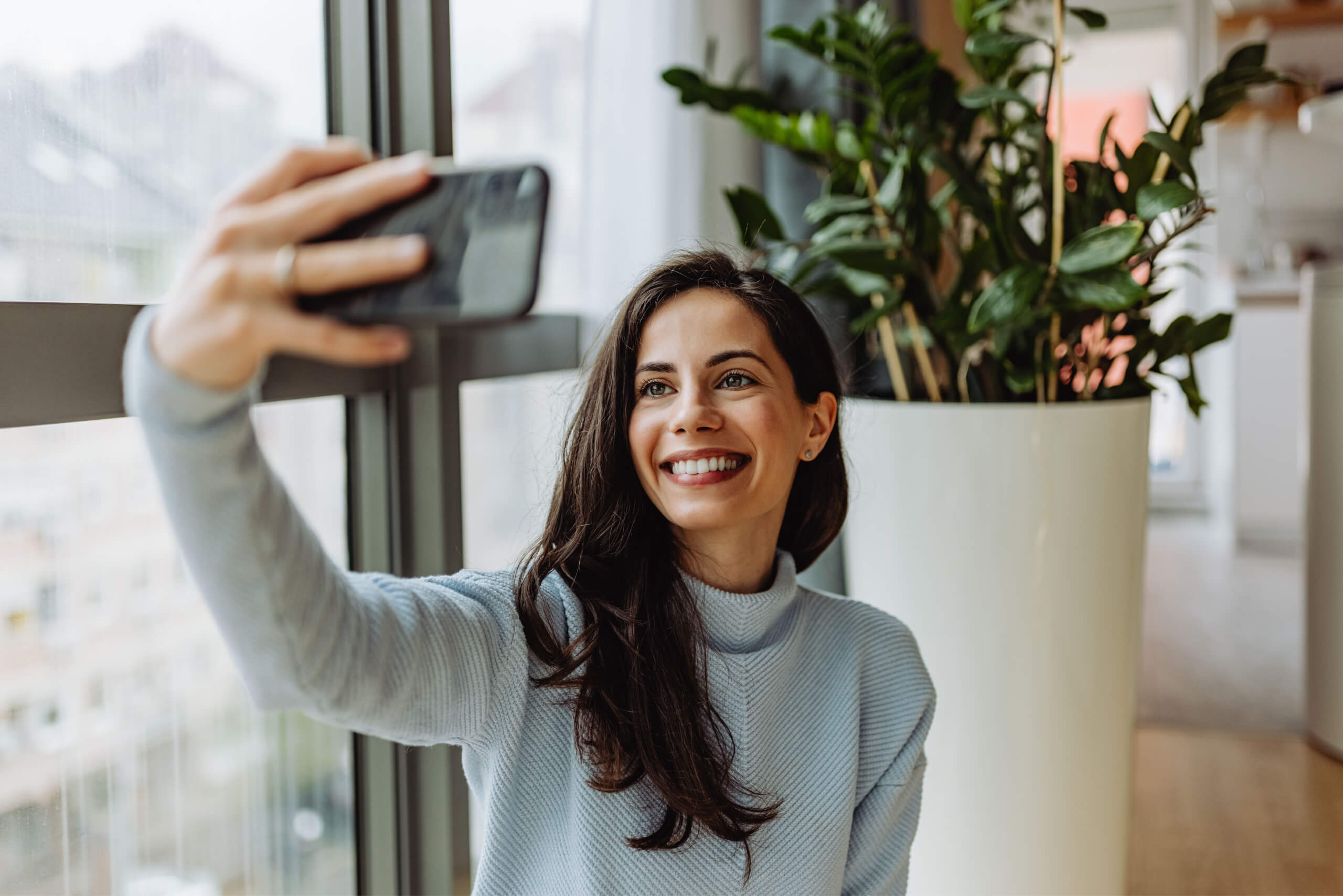 You woman taking a selfie to receive a virtual smile makeover from MP Orthodontics